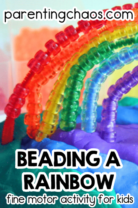 Beading a rainbow fine motor activity for kids. Colorful pony beads threaded onto pipe cleaners in rainbow order, curved to form a rainbow shape, with playdough as the base. Text reads: “Beading a Rainbow – fine motor activity for kids – parentingchaos.com”.