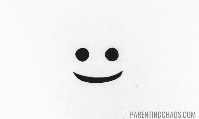 Two black paper circles for cow nostrils and a black paper smile, ready to be added to a cow paper plate craft.