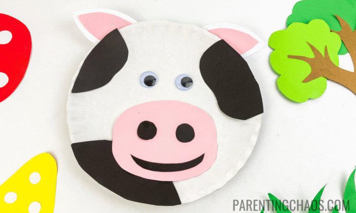 Easy cow paper plate craft made with black and pink paper details, googly eyes, and a white paper plate, perfect for preschoolers and farm-themed activities.
