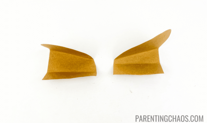 Brown paper dog ears folded into thirds, ready to be glued, as part of a paper plate dog craft activity.