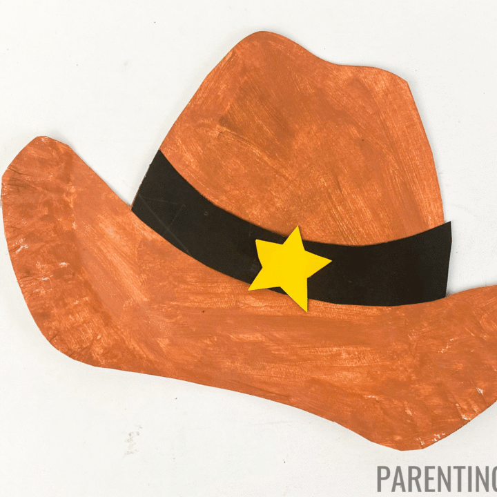 Paper plate cowboy hat craft painted brown with a black band and a yellow sheriff star in the center.