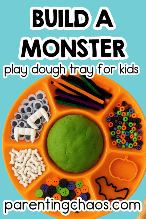 Halloween-themed playdough tray with vampire fangs, pipe cleaners, colorful beads, googly eyes, and green playdough.