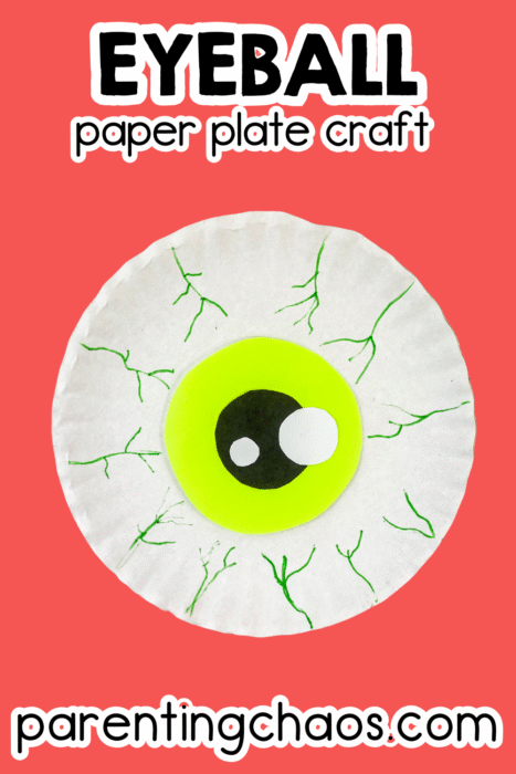 A spooky Halloween paper plate eyeball craft with green iris, black pupil, and white highlights on a red background.