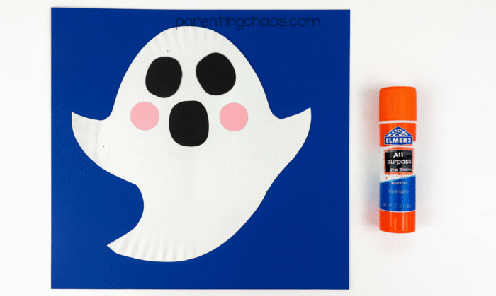 Ghost face with pink cheeks glued beside black eyes and mouth.