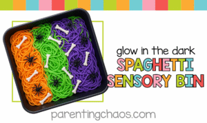 A bright, colorful promotional image featuring a glow-in-the-dark spaghetti sensory bin with Halloween colors, bones, and spiders, with text that says “Glow in the Dark Spaghetti Sensory Bin.”