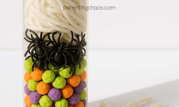 The sensory bottle filled halfway with yarn, layered above the spiders and clay balls, showing the build process of the spider sensory bottle.