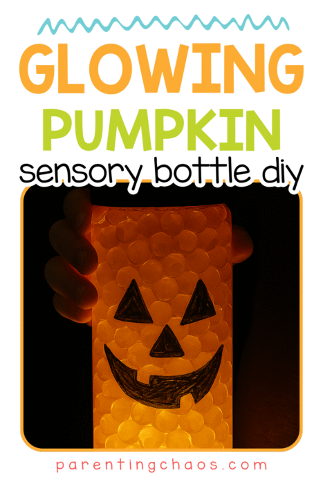 A child’s hand holds a glowing pumpkin sensory bottle with orange water beads and a smiling face. The text reads “Glowing Pumpkin Sensory Bottle DIY.”