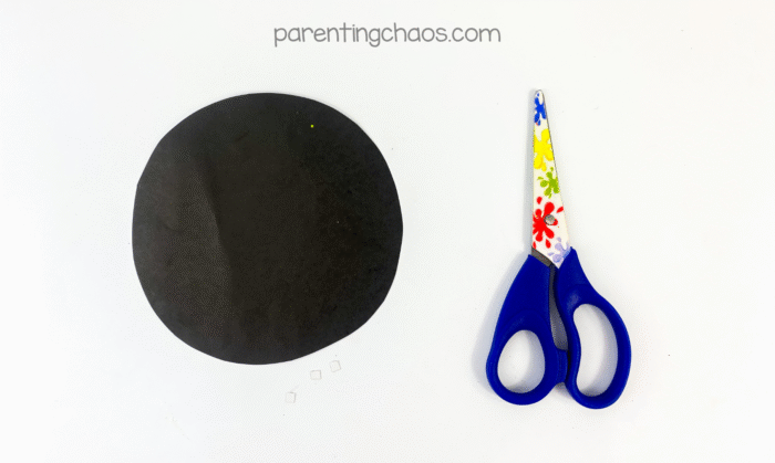 Black paper circle with scissors next to it.