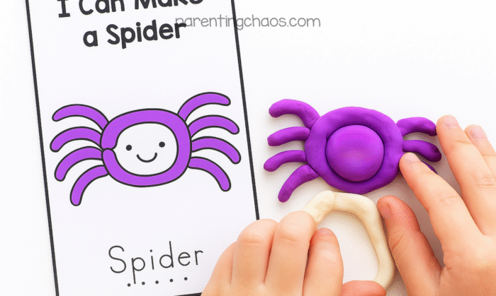 Child building a purple playdough spider beside an “I Can Make a Spider” task card. The card shows a smiling purple spider, and the child’s hands are shaping the playdough to match it.