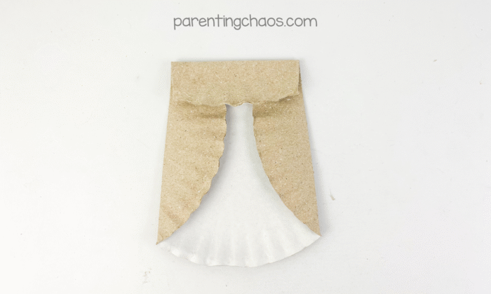 Top flap of the paper plate folded downward to form the owl’s head shape.