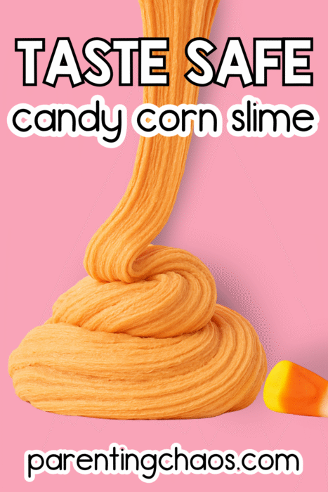 Pile of orange candy corn slime with a candy corn on top on a pink background.