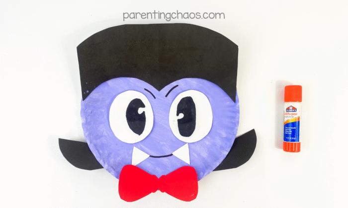 White paper vampire fangs glued under the smile on the paper plate face.