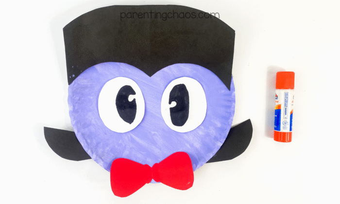 Vampire craft with eyes and bow tie glued onto the purple paper plate face.