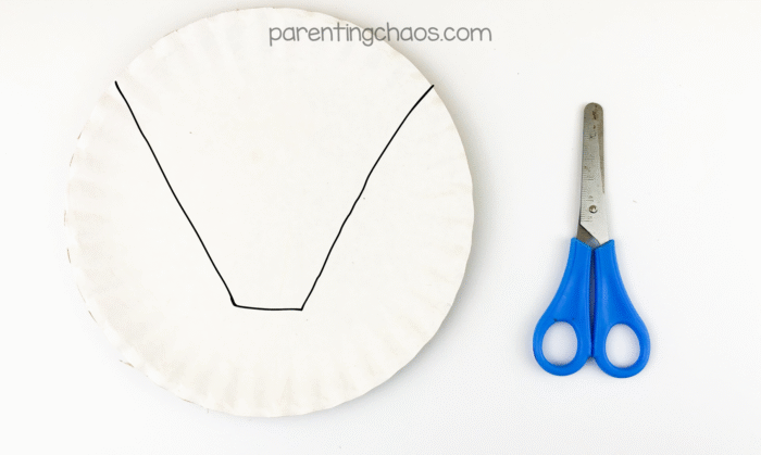 Paper plate with V-shaped lines drawn for cutting to form the broom bristles.