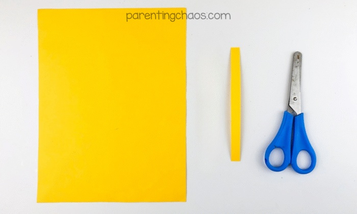 Yellow construction paper with a narrow strip cut out for broom band.