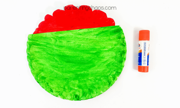 Red “brain” piece glued behind green plate half to form zombie head.