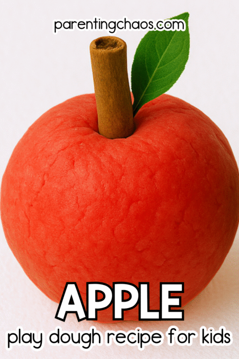 A red play dough apple with a cinnamon stick for a stem and a small green leaf. Text reads “Apple Play Dough Recipe for Kids.”