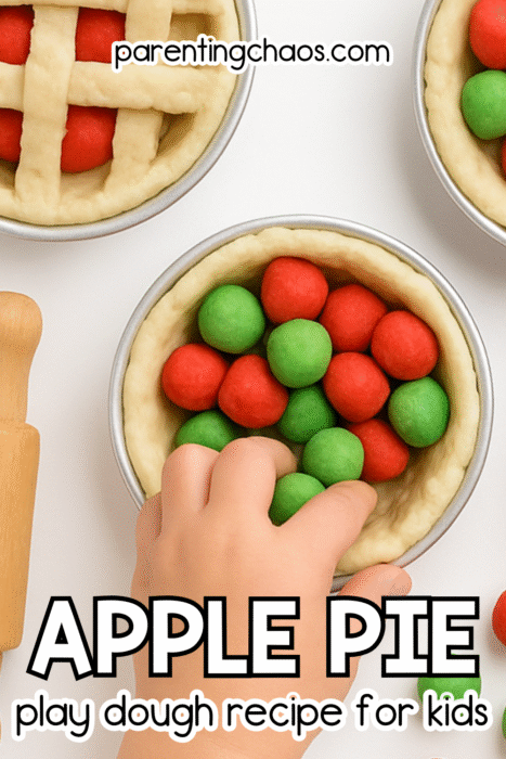 A child’s hands fill small pie tins with red and green play dough balls. One pie has a tan lattice top, and cinnamon sticks are placed nearby. Text reads “Apple Pie Play Dough Recipe for Kids.”