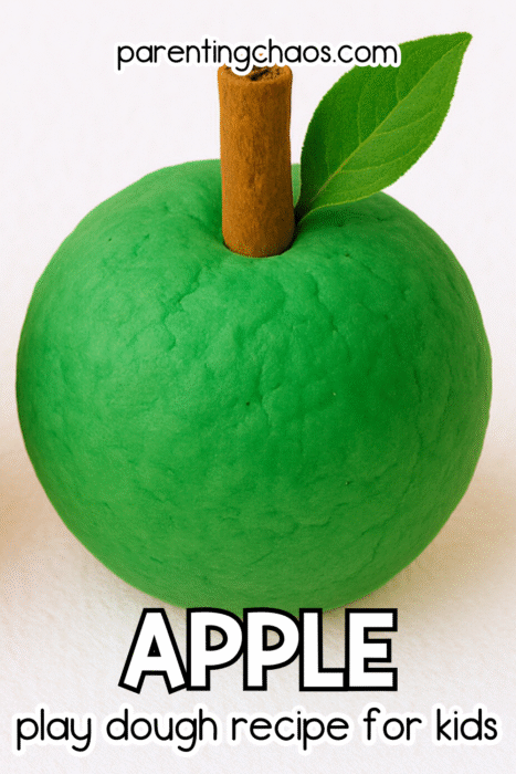 A green play dough apple with a cinnamon stick stem and a green leaf. Text reads “Apple Play Dough Recipe for Kids.”