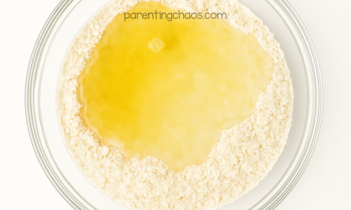 Wet ingredients poured into the center of the dry mix while making the apple pie playdough recipe.