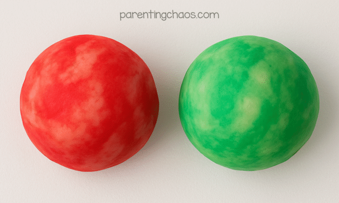 Bright red and green apple pie playdough balls after kneading, showing their festive holiday colors.