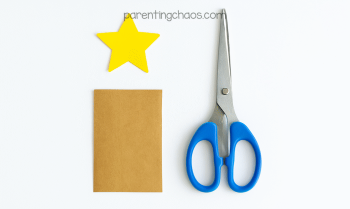 Brown rectangle and yellow star cut from construction paper with scissors, ready to be added to the paper plate Christmas tree craft for kids.