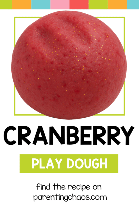 Ball of soft, red cranberry play dough with gold specks on a white background.