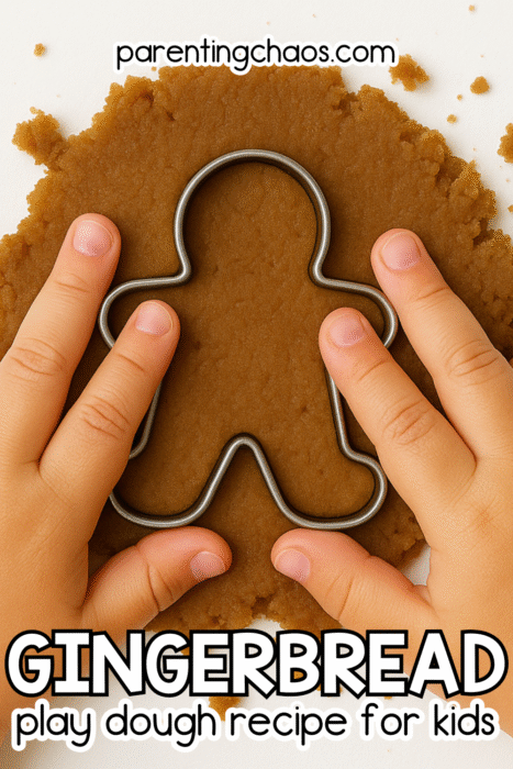 A child’s hands press a gingerbread man cookie cutter into flattened brown play dough on a white table. Text on the image reads “Gingerbread Play Dough Recipe for Kids.”