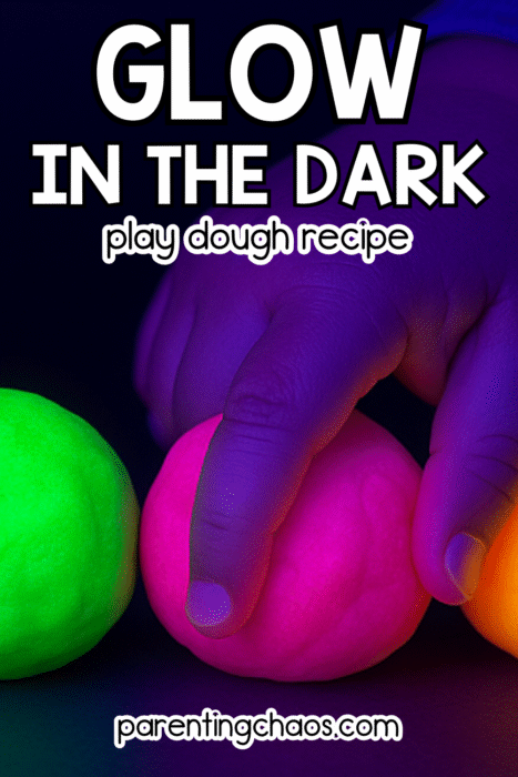 Child’s hands playing with bright glowing playdough balls under blacklight — glow in the dark play dough recipe for kids from Parenting Chaos.