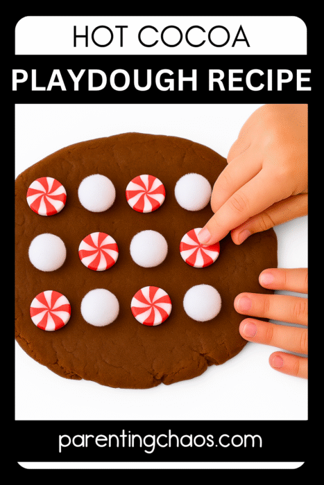 Child arranging red-and-white peppermint buttons and white pom-poms in rows on rolled-out brown hot cocoa playdough.
