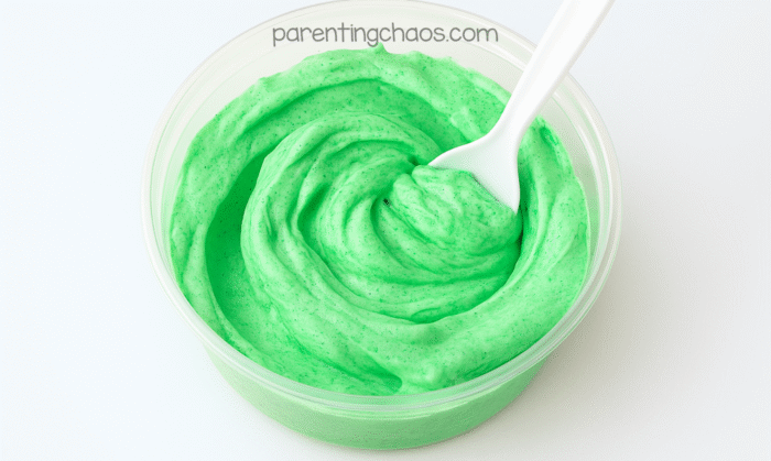 Bowl of freshly mixed bright green puffy paint with a spoon, showing its fluffy texture and smooth consistency.