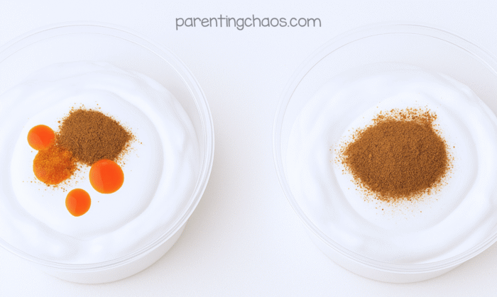 Two bowls of shaving cream with pumpkin spice and orange food coloring added on top, ready to mix for pumpkin spice puffy paint.