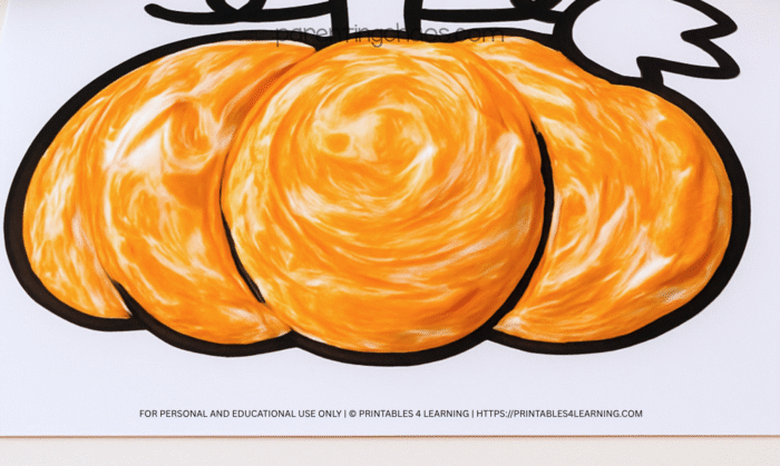 Close-up of the finished pumpkin printable covered in textured orange pumpkin spice puffy paint.