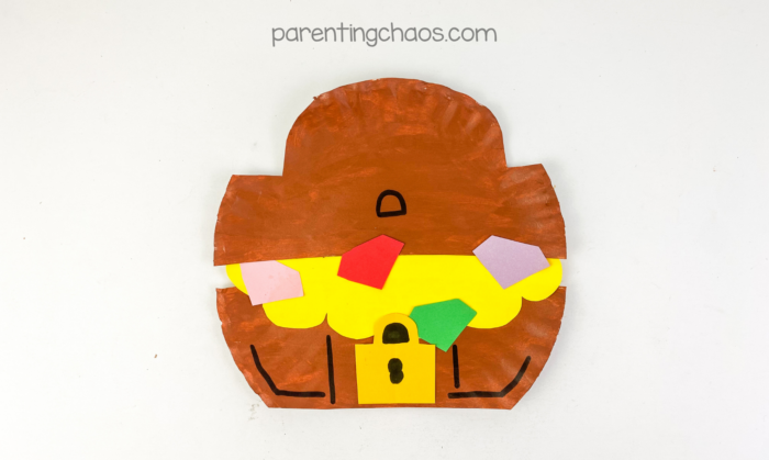 Completed treasure chest paper plate craft for kids showing open lid and colorful paper treasure.