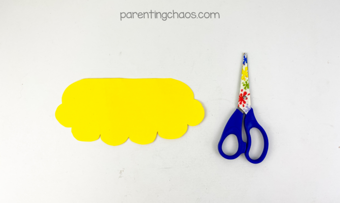 Yellow scalloped paper cutout used as gold coins for a treasure chest paper plate craft.