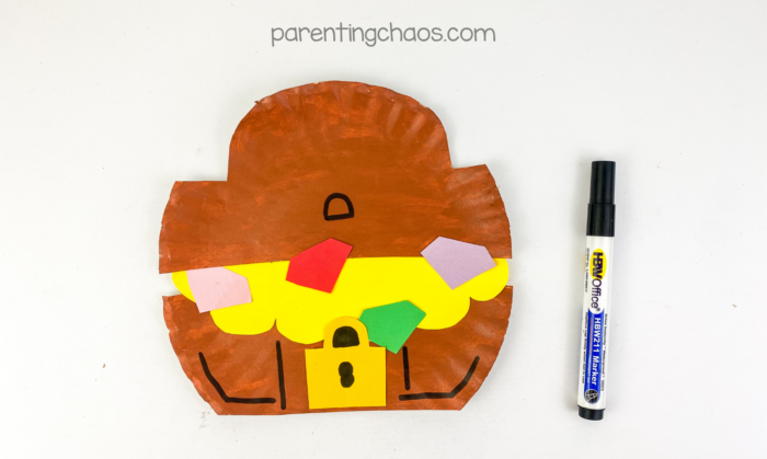 Treasure chest paper plate craft with drawn details using black marker.