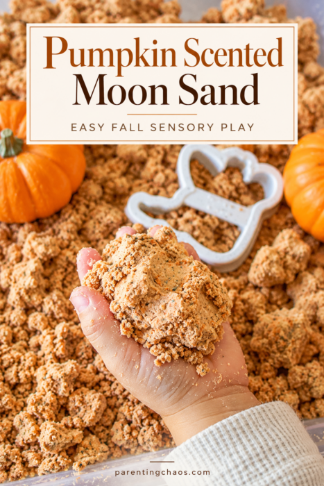 Pumpkin scented moon sand activity with a child holding and squeezing the crumbly sensory mixture, orange pumpkins, and a white fall-shaped cookie cutter. Text reads “Pumpkin Scented Moon Sand” and “Easy Fall Sensory Play.”